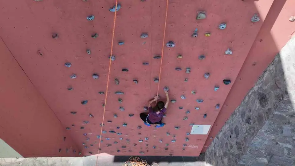 Looking down the red outdoor wall, with two ropes running to a climber halfway up