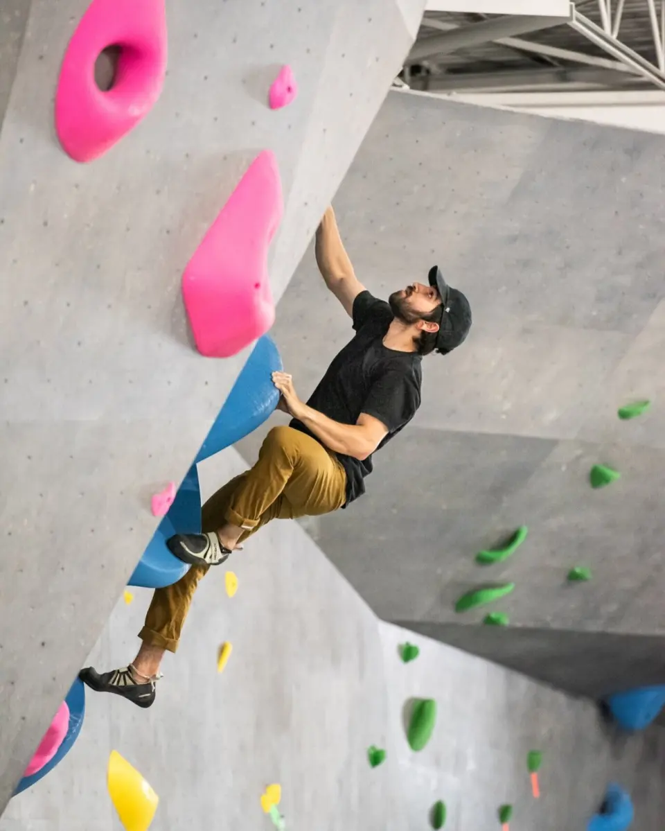 Climber on an arête between grey wall panels