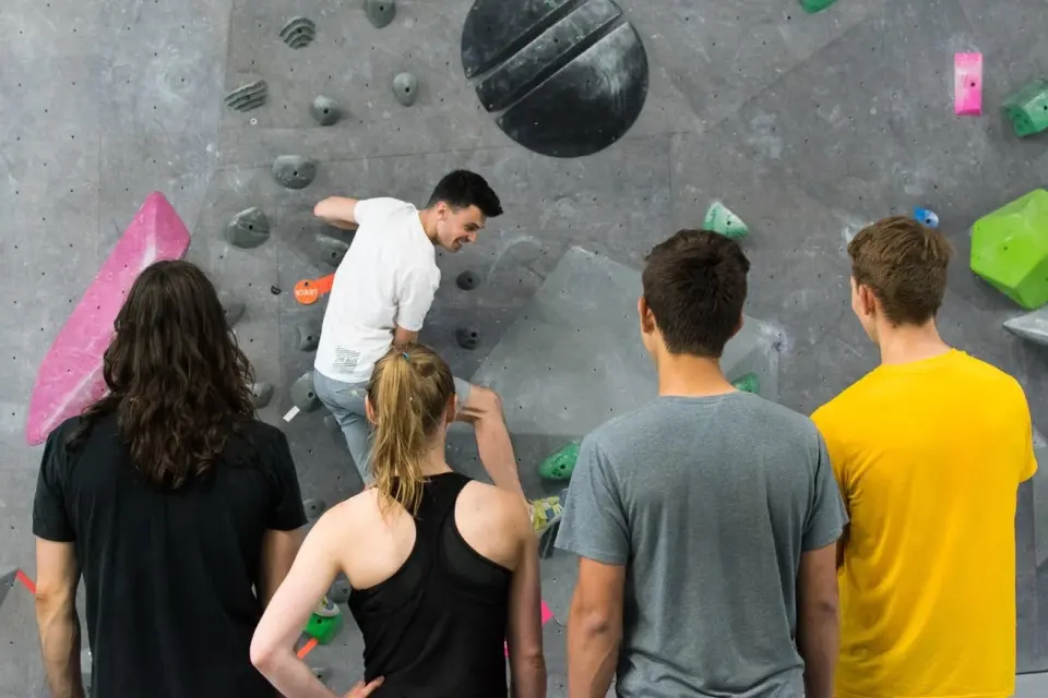 Coach demonstrating a move to a beginners' class at the wall