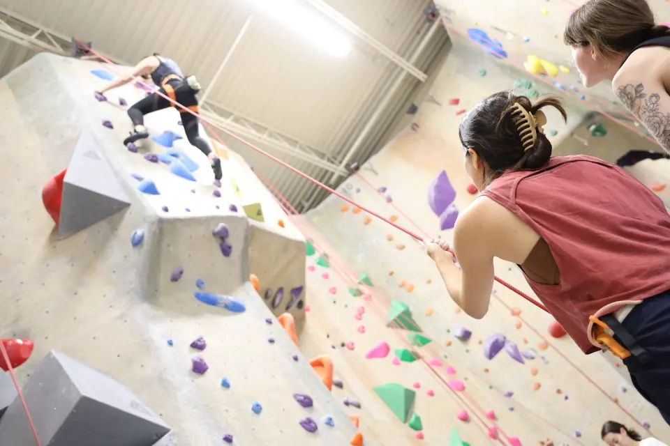 Belayers watching a climber on the tall top-rope walls