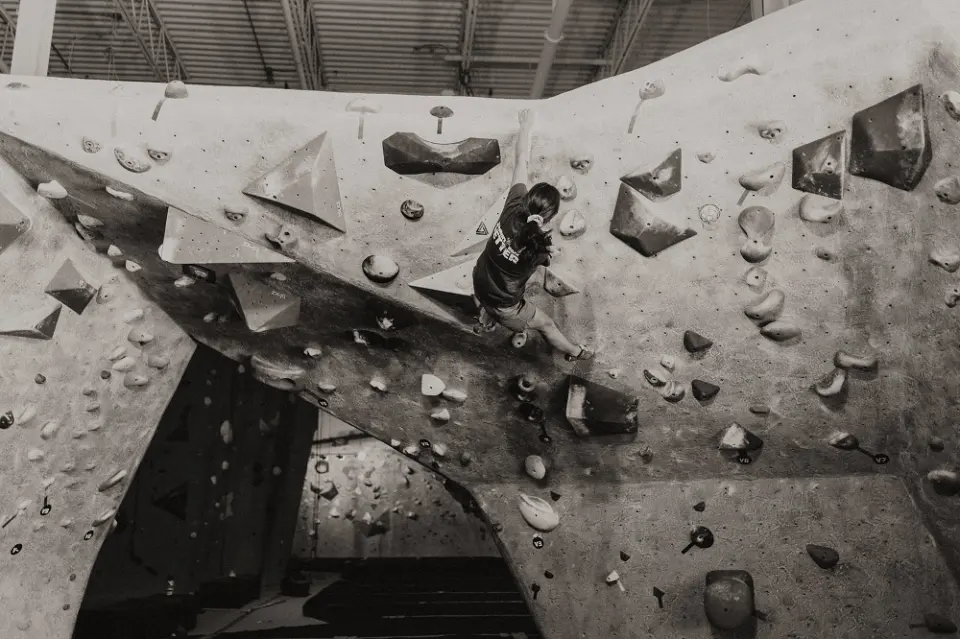 Black-and-white shot of a climber on an overhanging bouldering arch