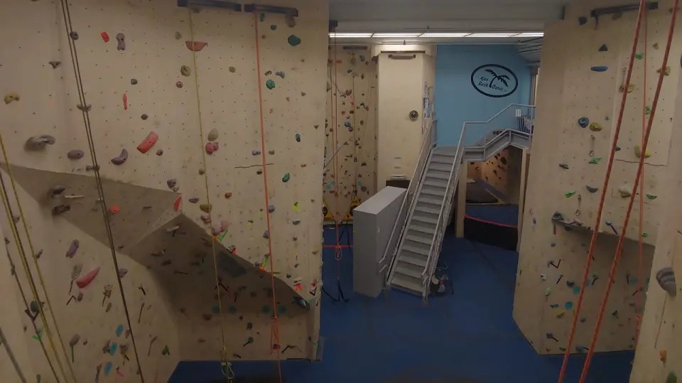 Tall top-rope walls on either side of a staircase up to a mezzanine bouldering area