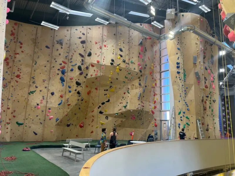 High lead wall with an overhanging prow above a turf floor and benches