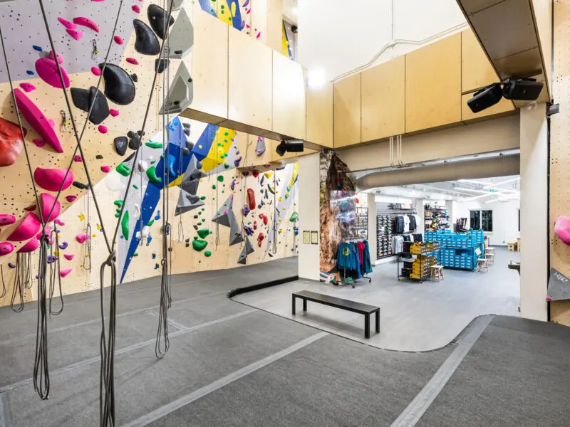 Top ropes hanging beside the climbing walls, with the gear shop beyond