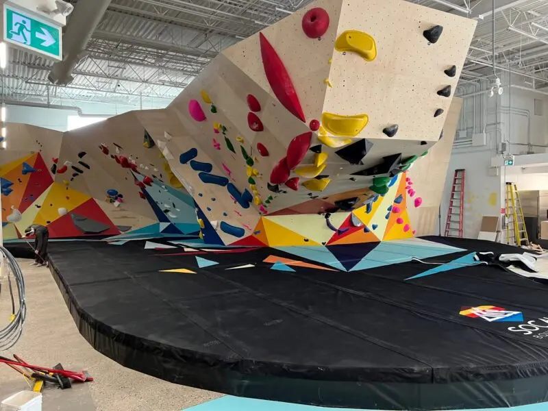 Steep overhanging boulder with large volumes above a curved padded floor