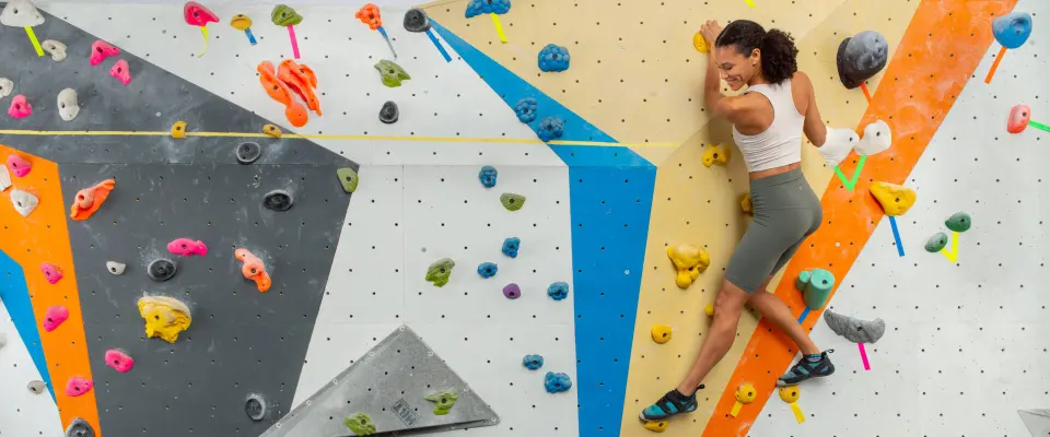 Climber traversing a colourful wall at Hub Climbing's Mississauga gym