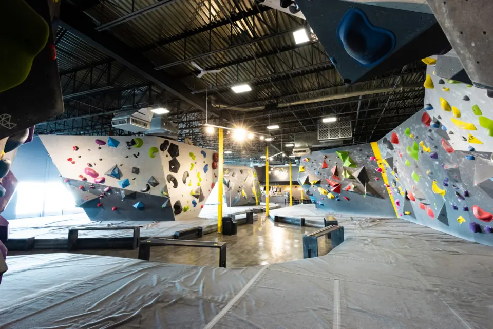 Bouldering hall with matted islands and benches, and the bistro at the far end