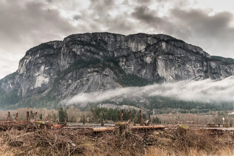 The granite walls of the Stawamus Chief above Squamish, with low cloud drifting across the forest below