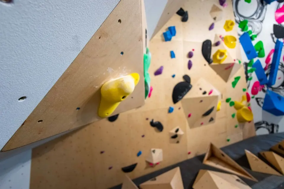Plywood bouldering wall with angled volumes and colourful holds
