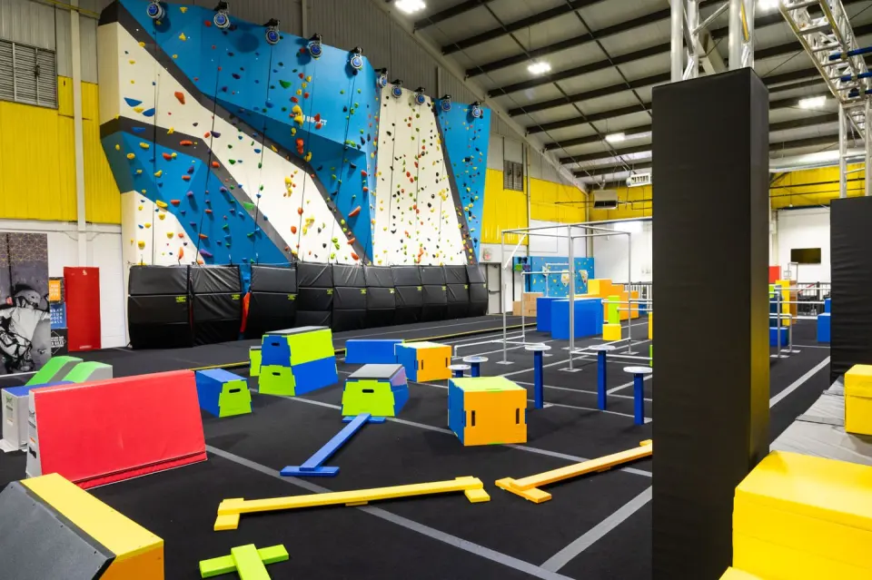 Blue and white rock wall with auto-belays beside the ninja course at Ken Giles Recreation Centre, Brampton