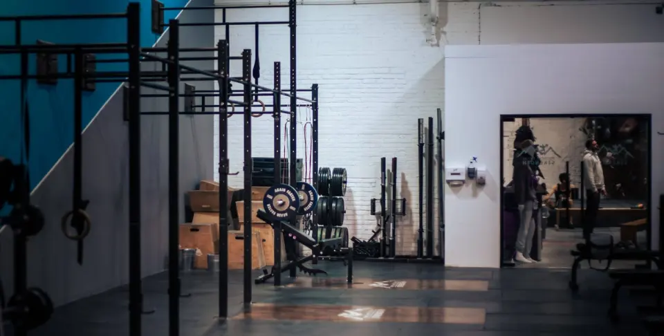 Strength room with squat racks, weight plates and plyometric boxes
