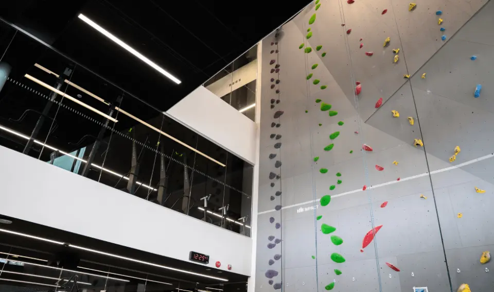 Tall top-rope wall beside the glass-fronted fitness centre