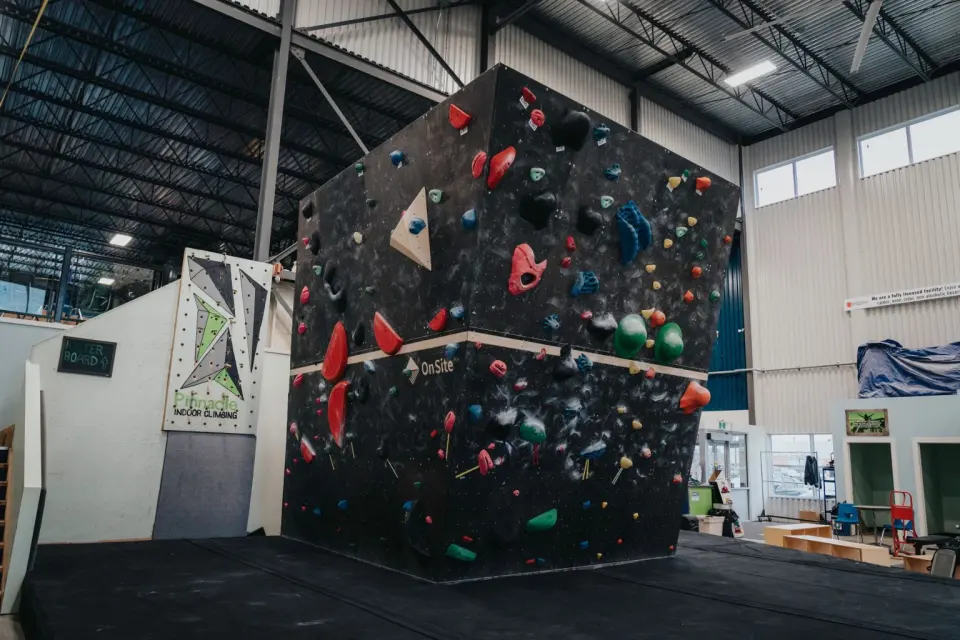 Freestanding bouldering block in a tall, bright climbing hall