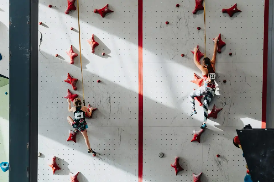 Two young climbers racing up the lanes of a speed climbing wall