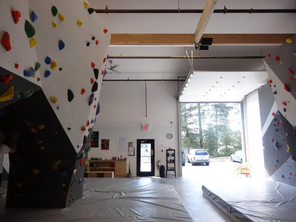 Bouldering walls beside an open roller door looking out on the car park