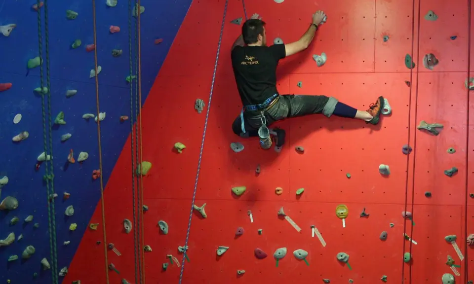Climber on a top rope on the red and blue roped wall