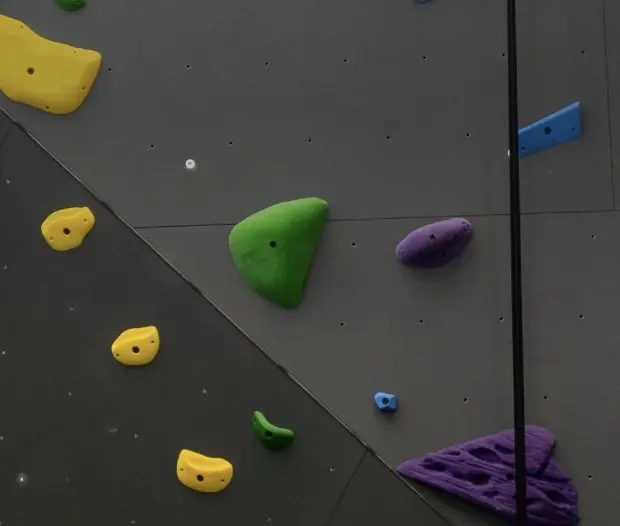 Coloured holds on the grey panels of the climbing wall