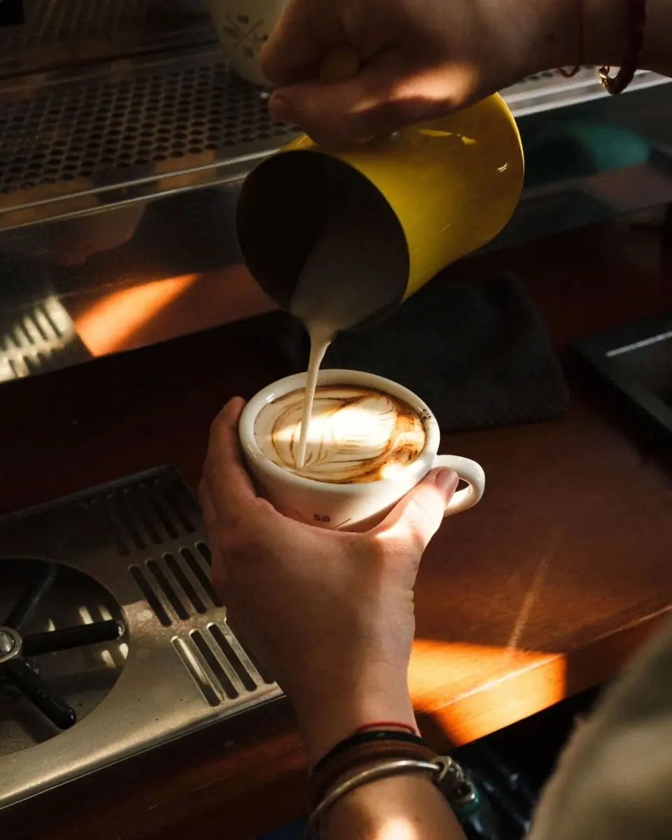 Latte art being poured at the café counter