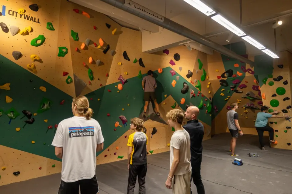Climbers in the bouldering room with green and plywood walls
