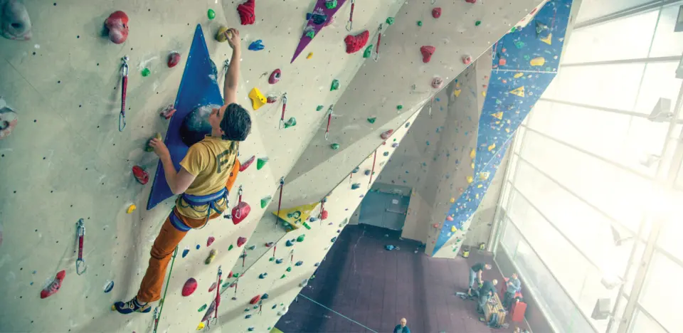 Climber leading on the 17 m main wall beside the arena's tall windows