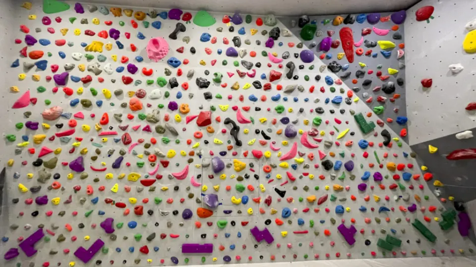 Bouldering wall densely covered in small multicoloured holds