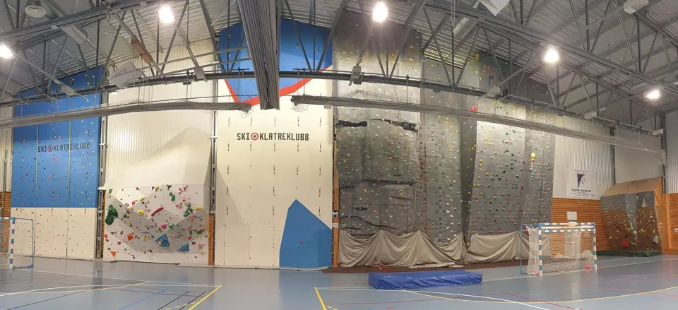 Roped and bouldering walls along one side of a sports hall