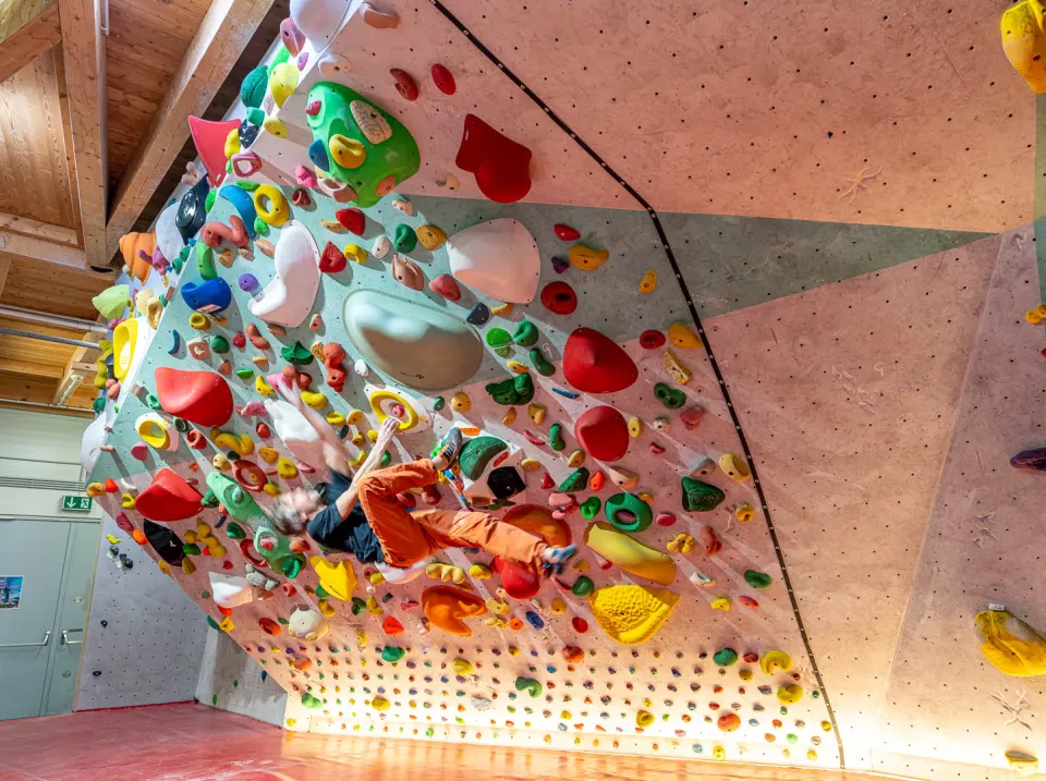 Climber on the steep spray-style training wall