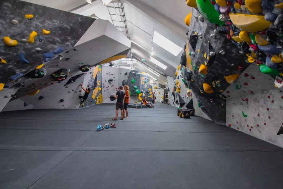 Bouldering hall with overhanging grey walls covered in colourful holds