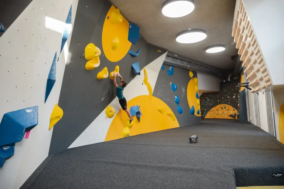 Climber on a grey and yellow competition-style wall