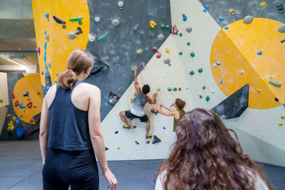 Climber being spotted while two others watch