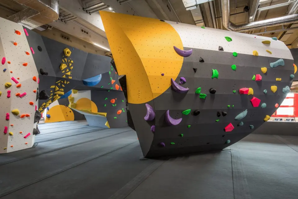 Empty bouldering hall with a large curved wall of colourful holds
