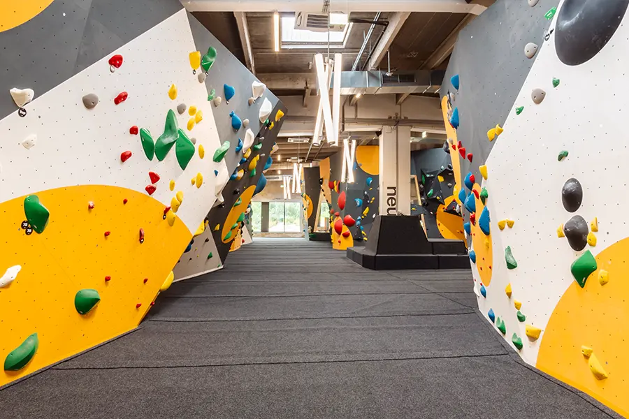 Aisle between yellow, white and grey bouldering walls