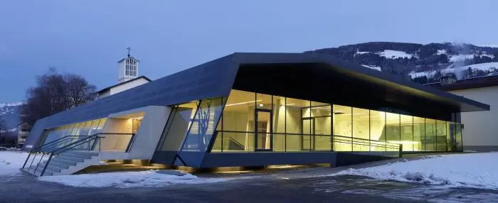 Glass-fronted building that houses the climbing hall, lit at dusk