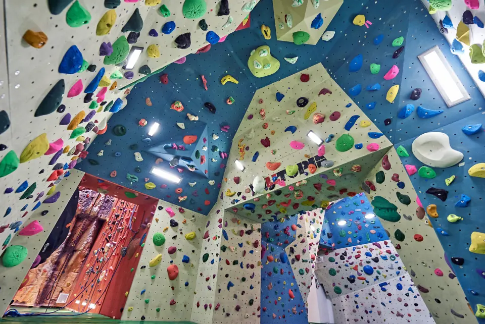 Bouldering room with steep blue overhangs covered in holds
