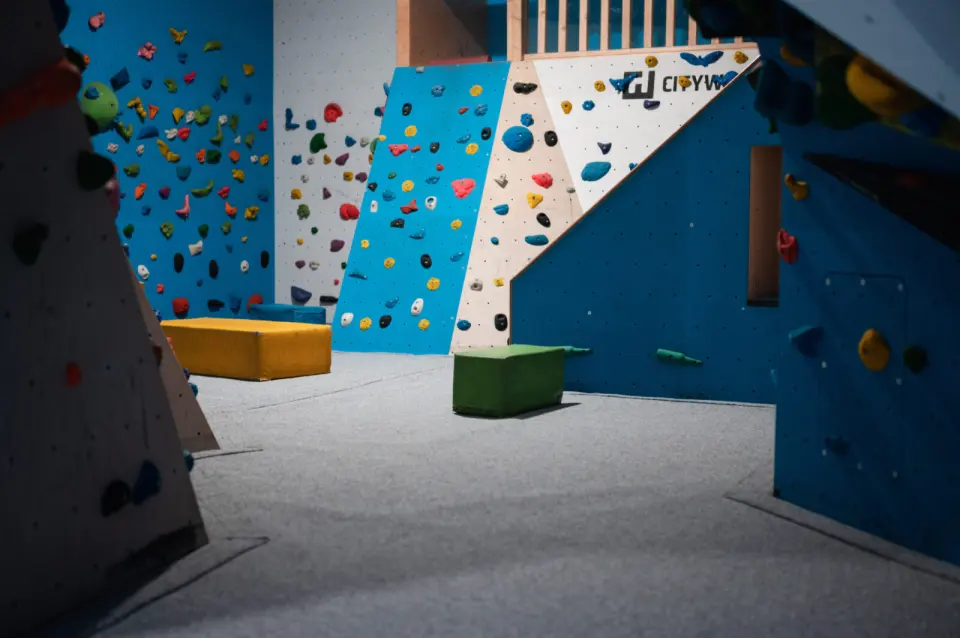 Blue and white bouldering walls above grey matting