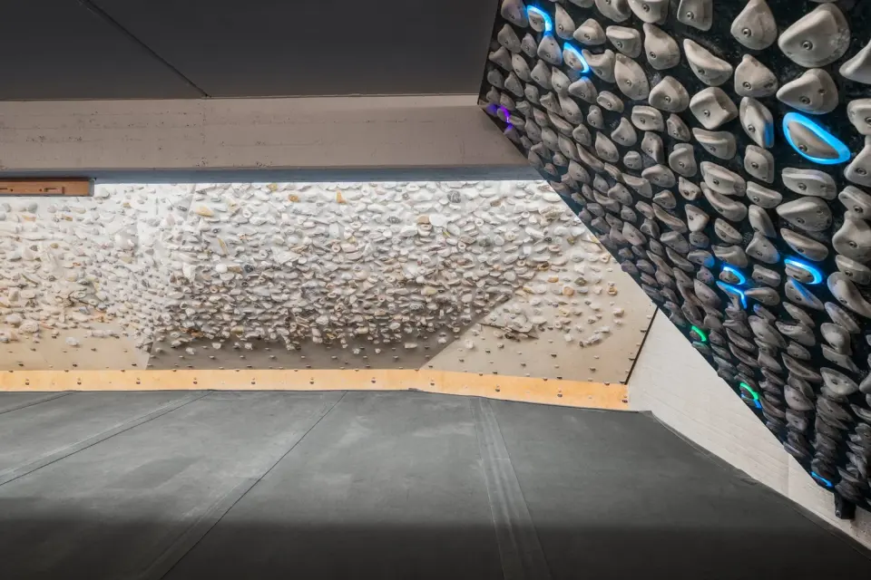 Training board covered in rock holds beside a board with grey holds