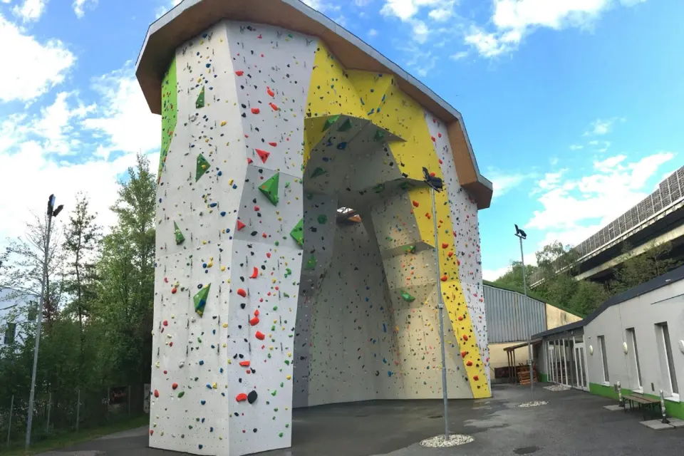 Outdoor climbing tower with an overhanging yellow arch