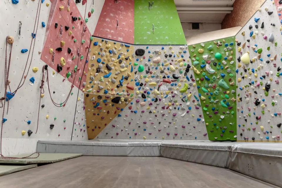 Small climbing room with angled panels, ropes and crash mats