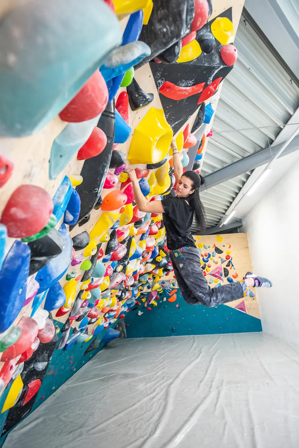 Climber hanging from big holds on a steep overhang