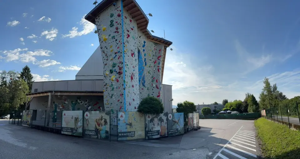 Kletterhalle Salzburg's outdoor climbing tower beside the hall under a blue sky