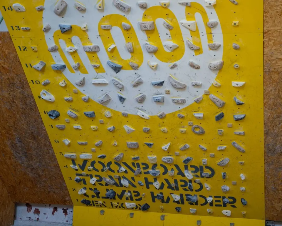 Yellow MoonBoard with its grid of wooden and grey holds