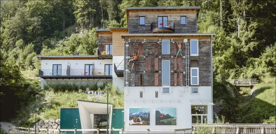 Climbers on the via ferrata up the timber front of the climbing hall building