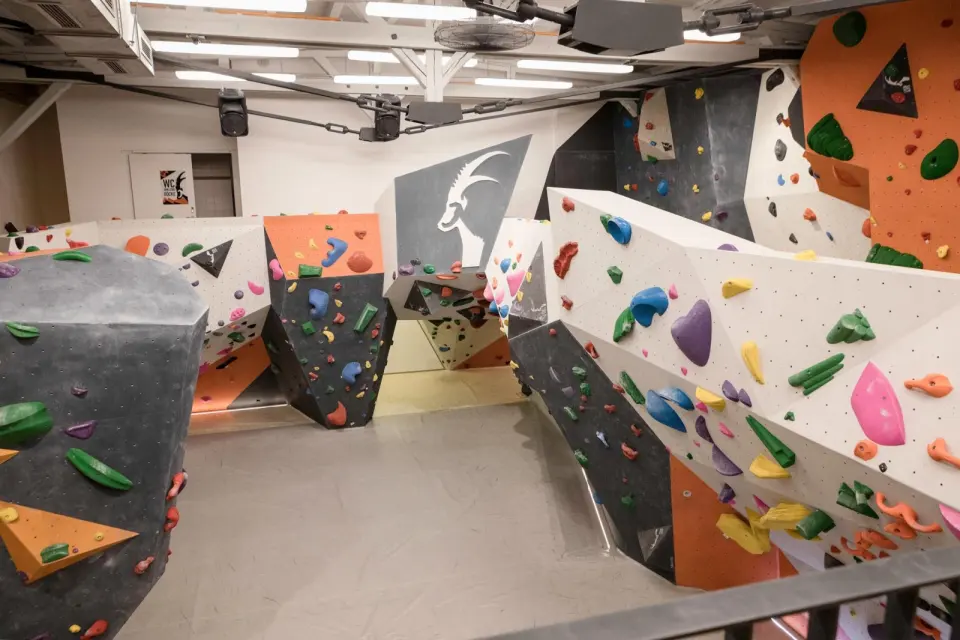 Angular bouldering walls in orange, grey and white seen from a balcony