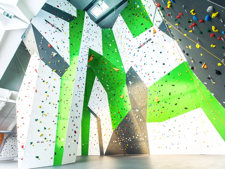 Tall green, white and grey lead walls under the hall's skylights