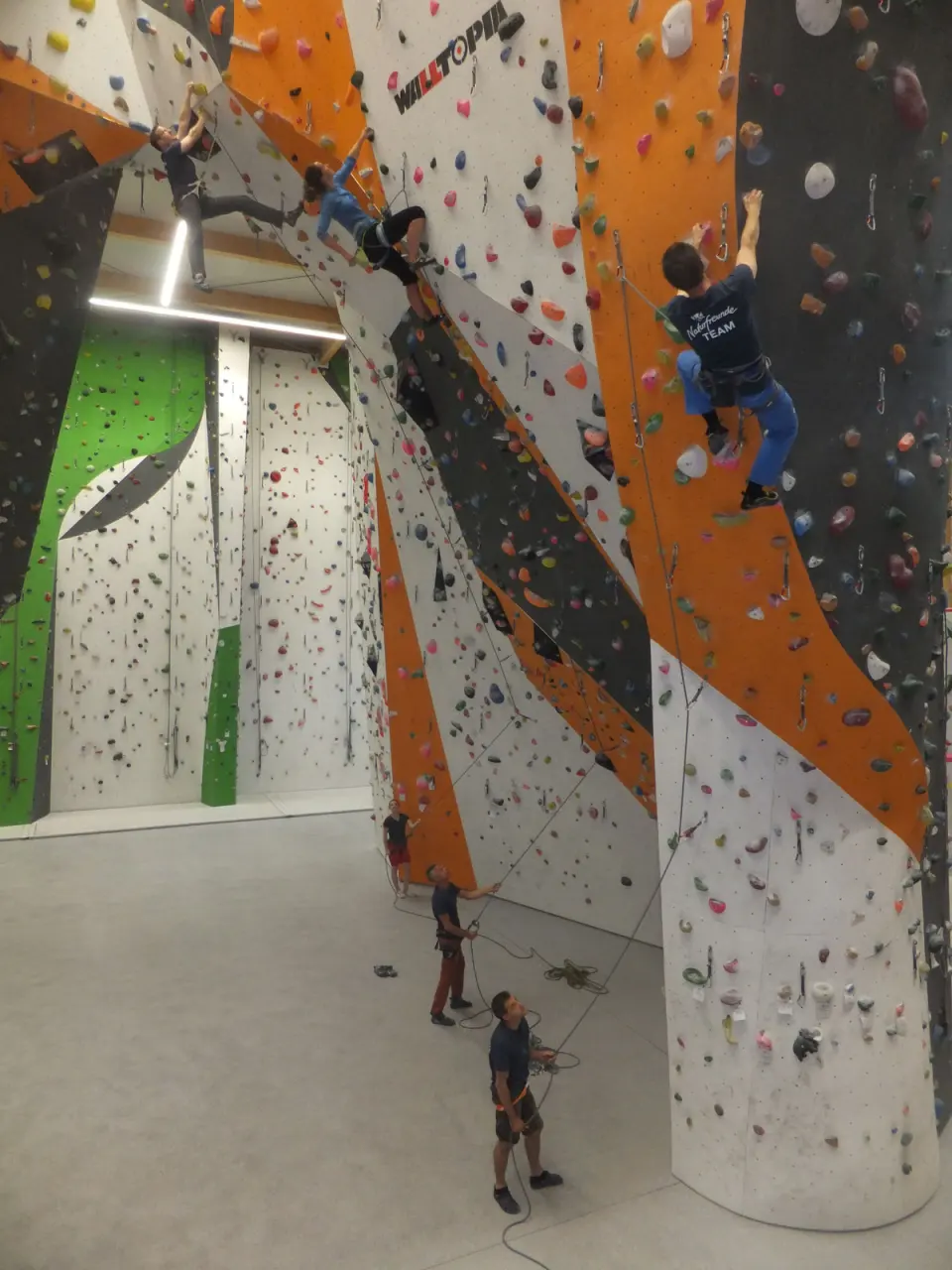 Lead climbers high on the walls with their belayers on the floor below