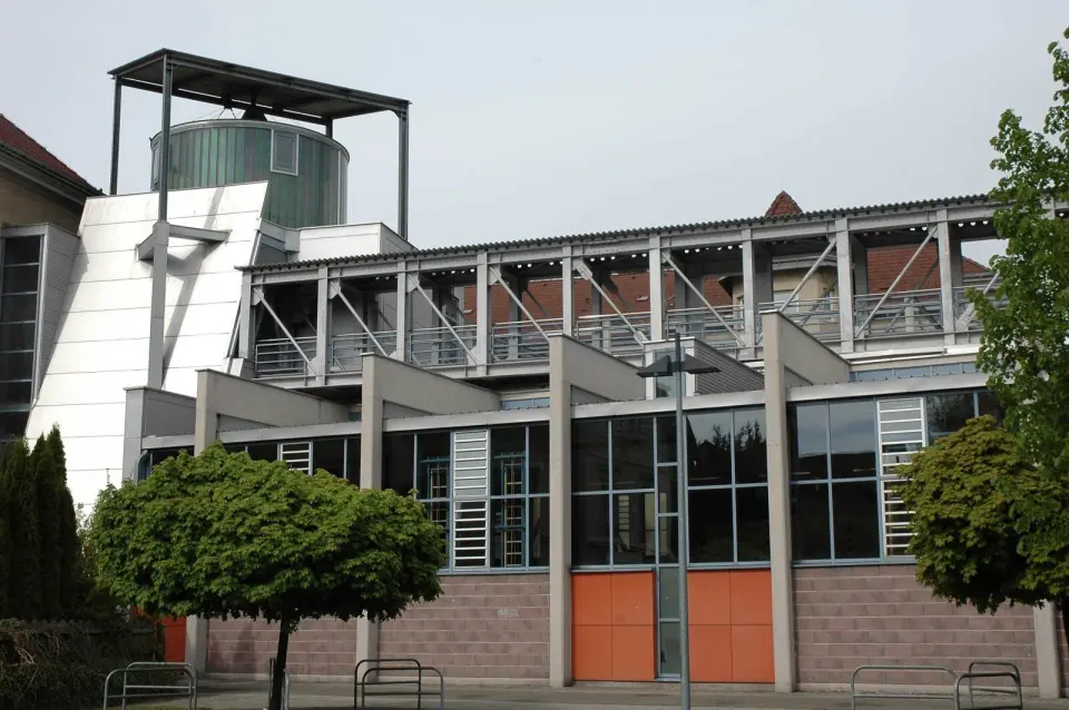 Outside of the climbing hall, a long glass-fronted building with a round glass-topped tower