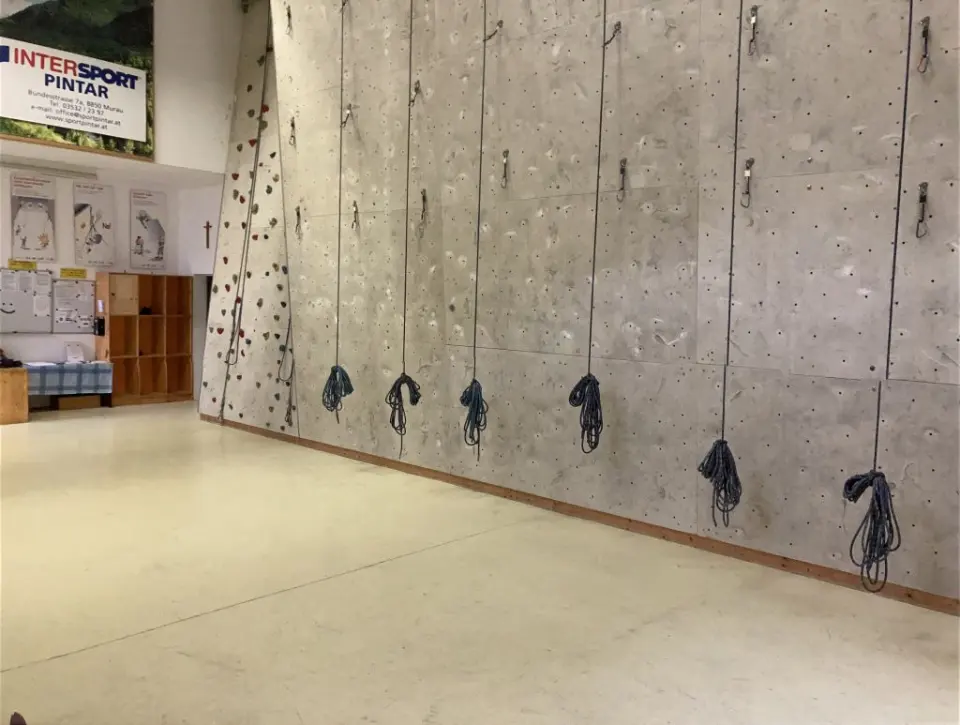 Grey lead wall with a rope coiled at the foot of each line