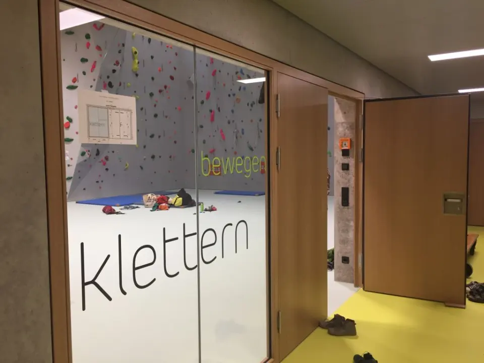 Glass doors lettered 'klettern' with the climbing walls visible behind them