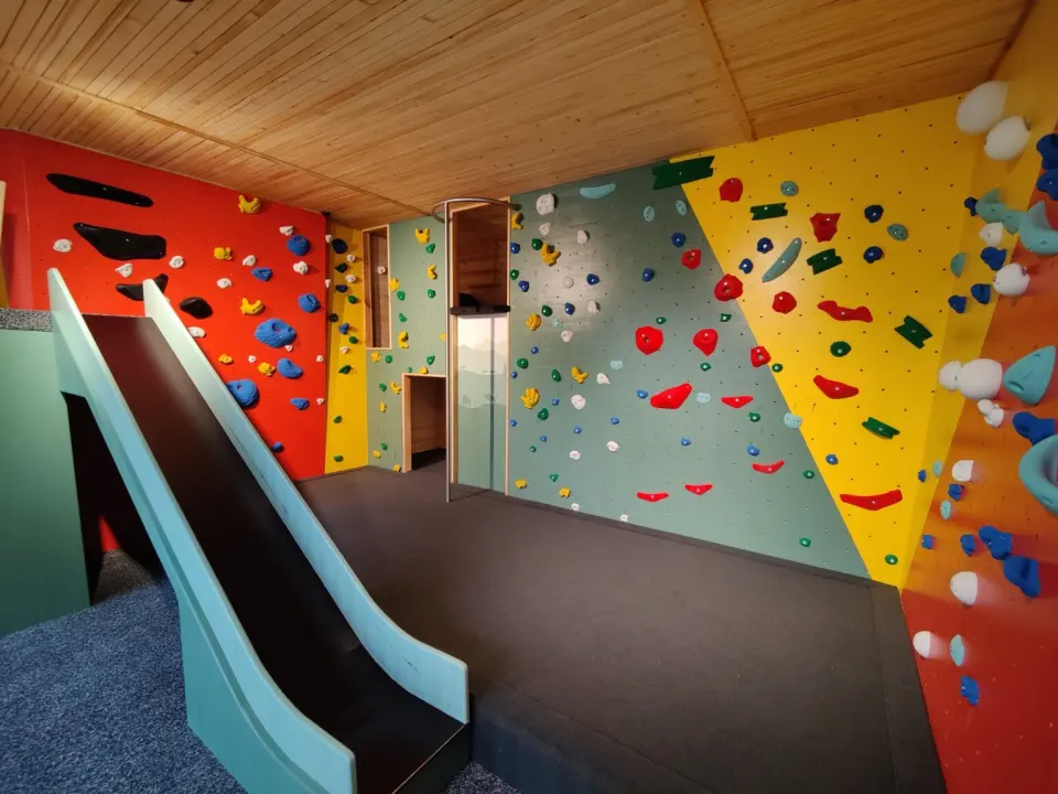 Children's area with red, green and yellow climbing walls and a slide