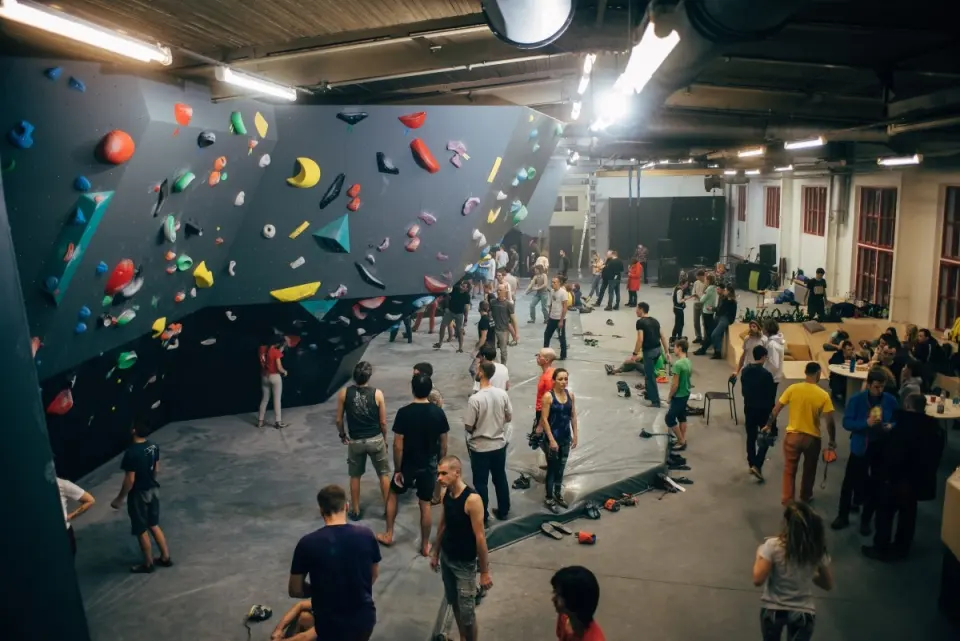 Climbers gathered in the main bouldering hall below the angled grey walls